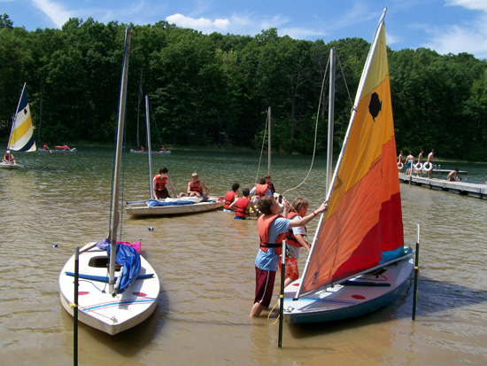 Scouts setting sail for sailing merit badge at summer camp